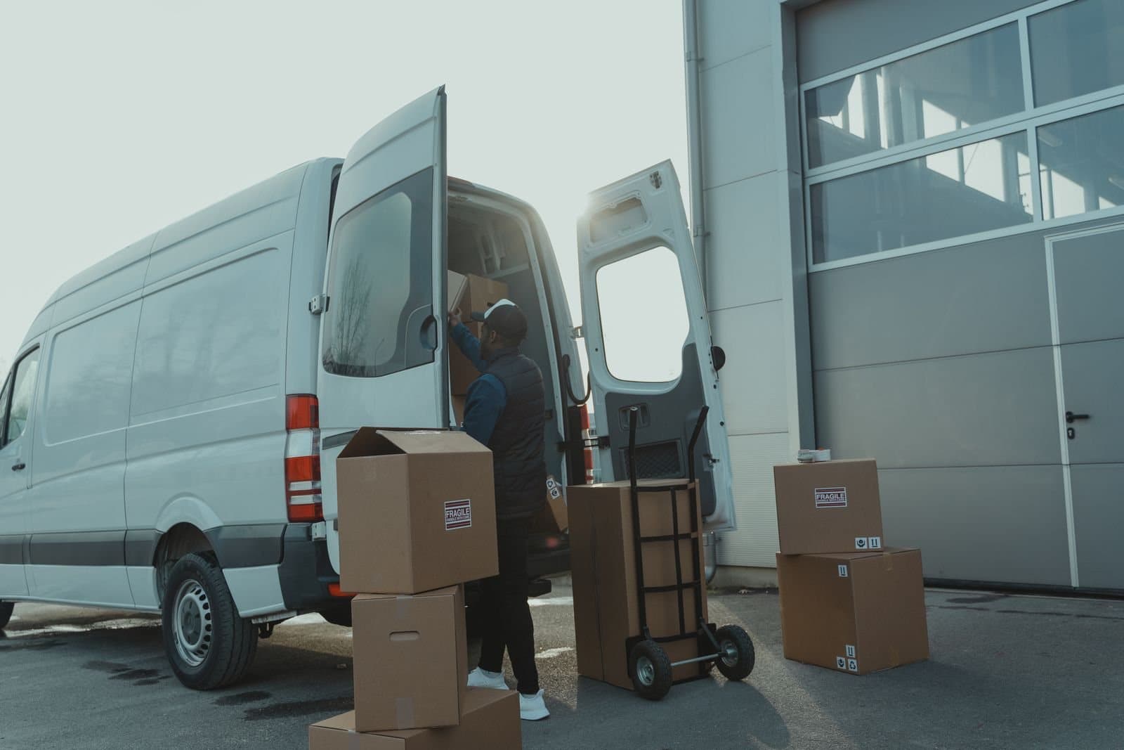 A courier loading parcels into a van for dispatch