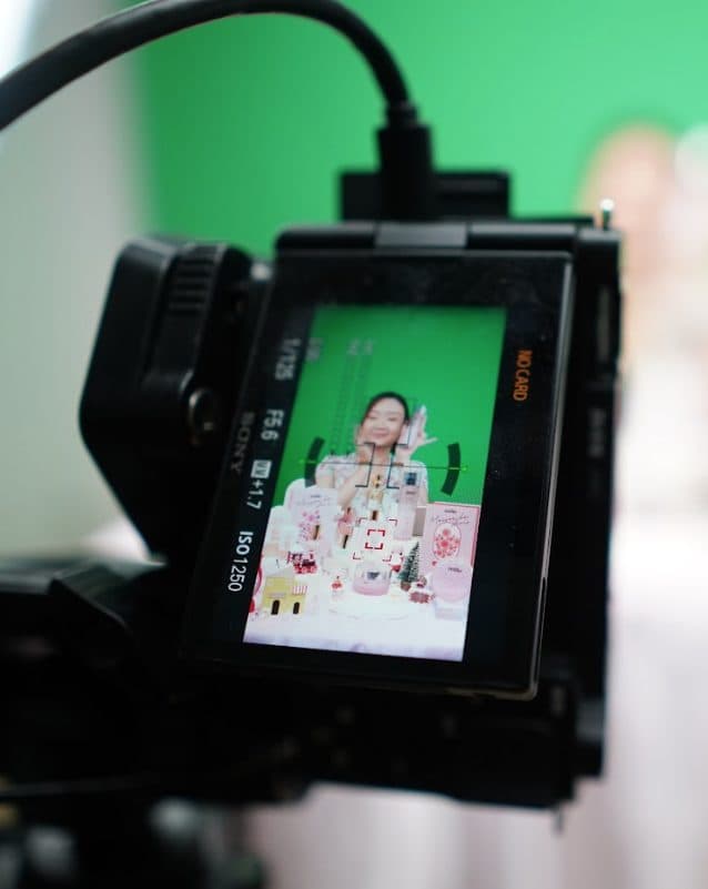 A camera monitor on a green-screen set